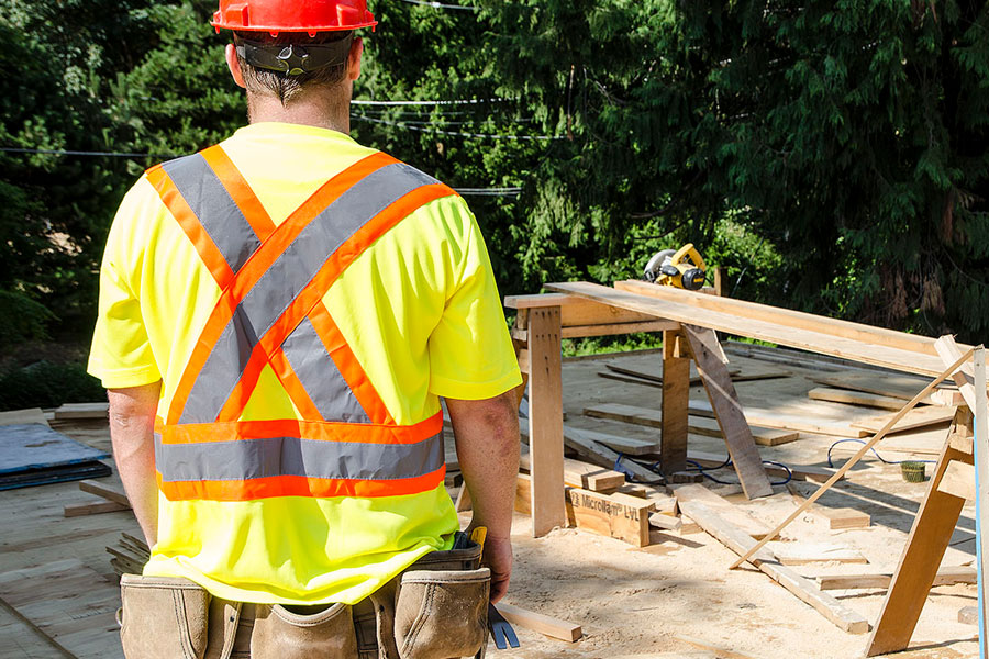 Man on work site wearing a hi visibility tshirt with retroreflective striping