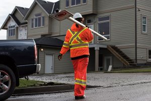 Man in Orange Hi Viz Carrying Traffic Sign