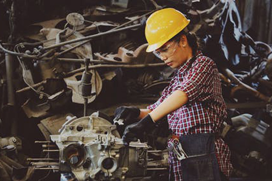 Woman wears eye, head and hand protection while operating machinery