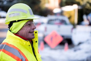 Man in green hi viz looks at worksite