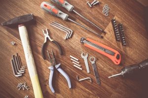 various tools lay on top of a wooden background